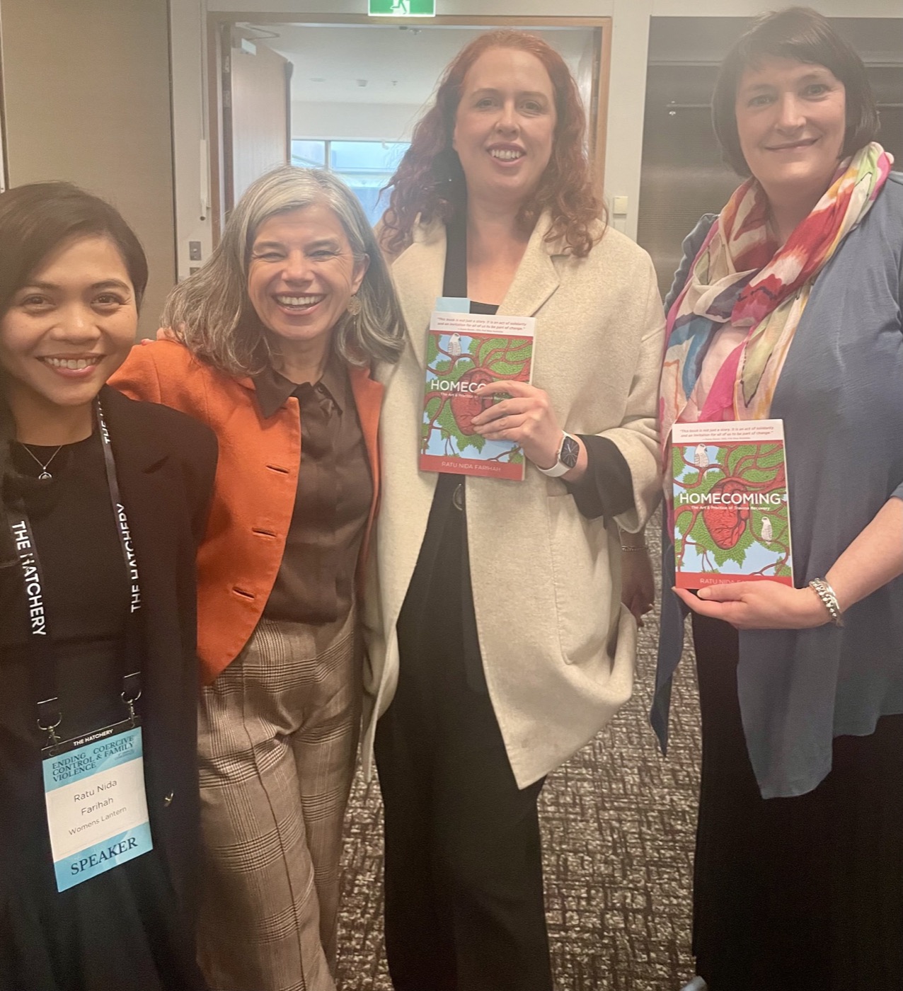 Ratu Nida with women leaders holding copies of Homecoming at a sector conference
