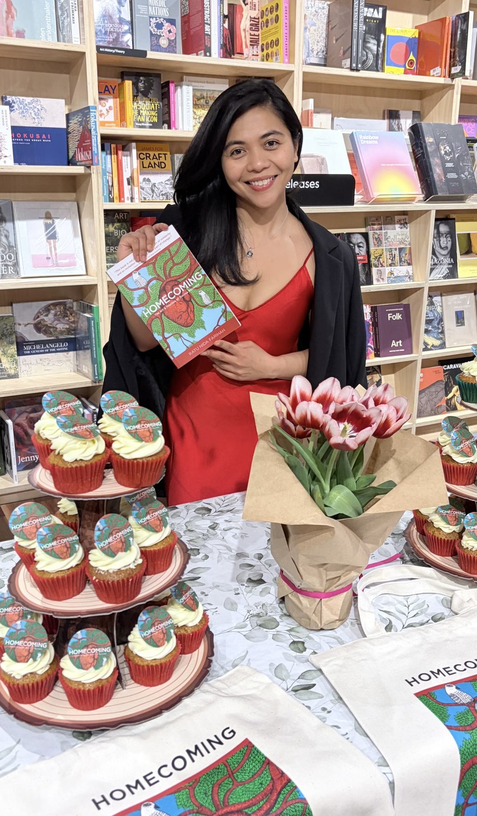 Ratu Nida holding Homecoming at the book launch with cupcakes and flowers