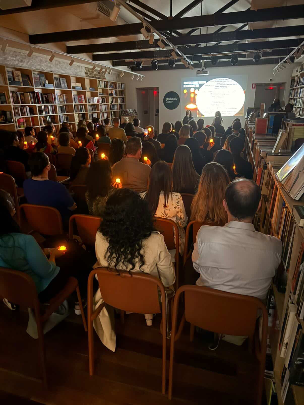 Audience seated with candlelight during the Homecoming book launch